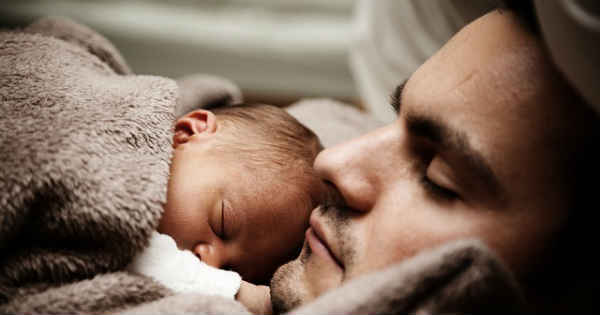 baby and father sleeping in bed