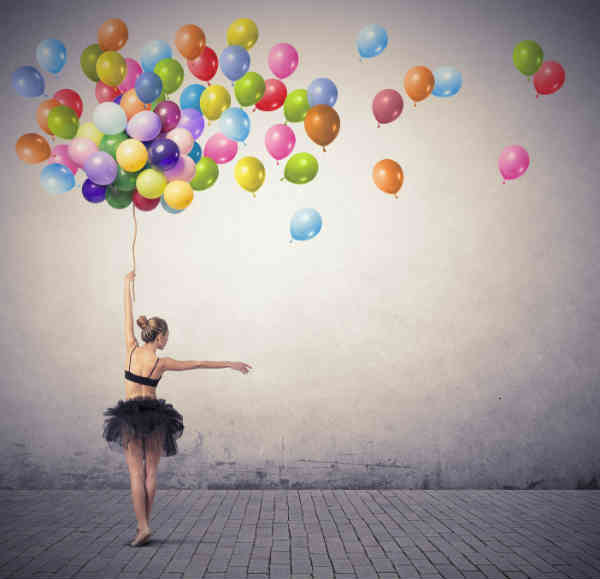 ballerina dancing and holding a bunch of balloons