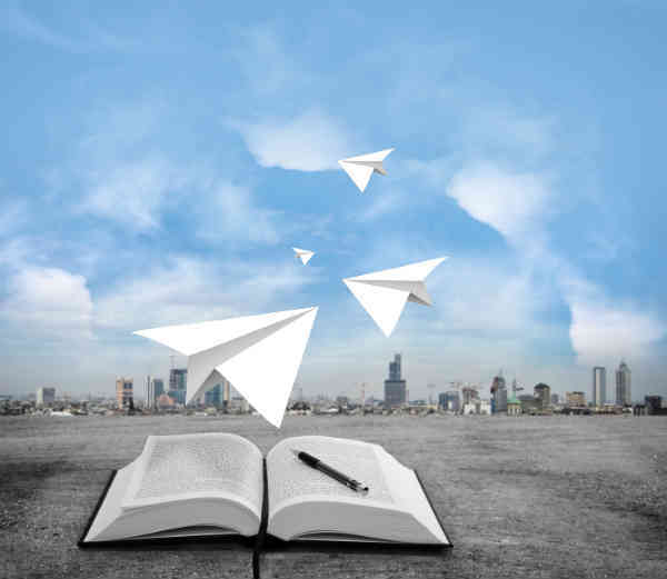 paper airplanes flying out of a book