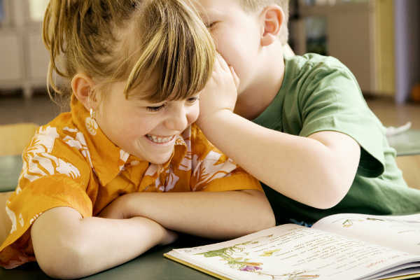 boy and girl whispering to each other