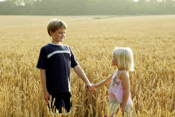 boy guiding a girl across a field