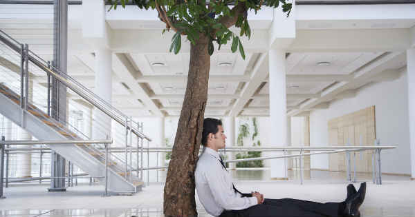 businessman meditating below a  three