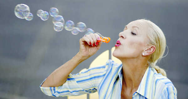 carefree woman blowing bubbles