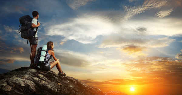 couple at the top of a mountain watching the sunset