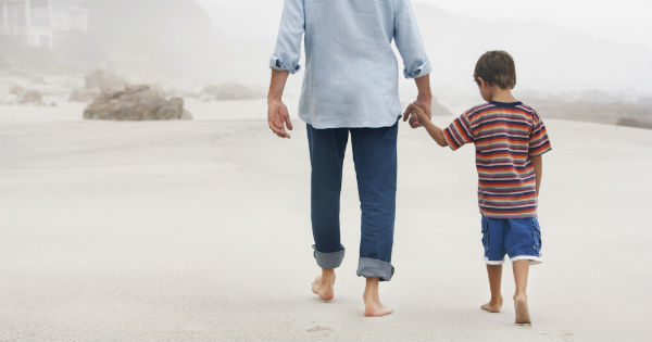 a father and son walking on the beach