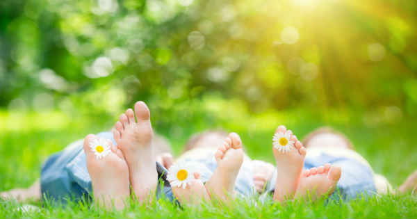 two people sleeping with bare feet on the grass