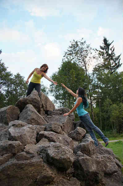 a friend is helping a friend climb to the top