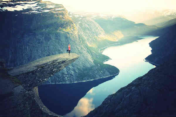 woman facing her fear on rock cliff