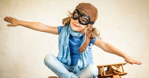 young girl pretending to fly an airplane