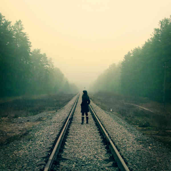 girl standing on train tracks
