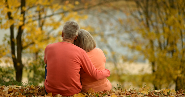 old couple hugging in woods