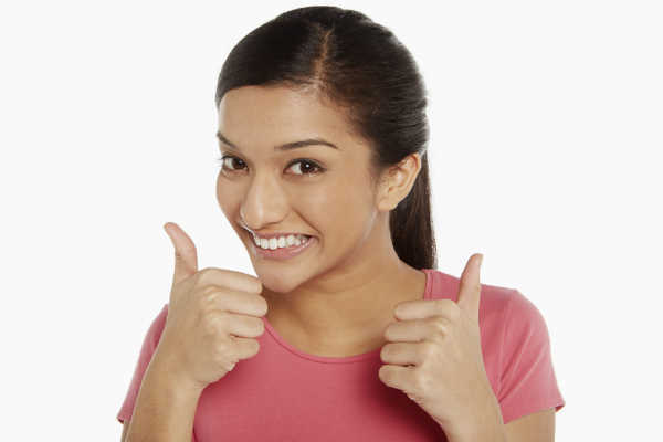 woman holding thumbs up and smiling