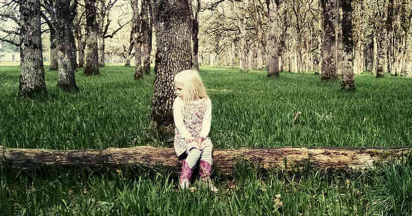 introverted girl sitting in woods