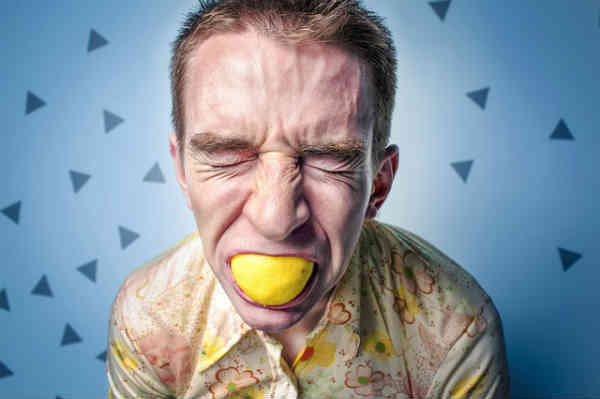 man with a tennis ball in his mouth