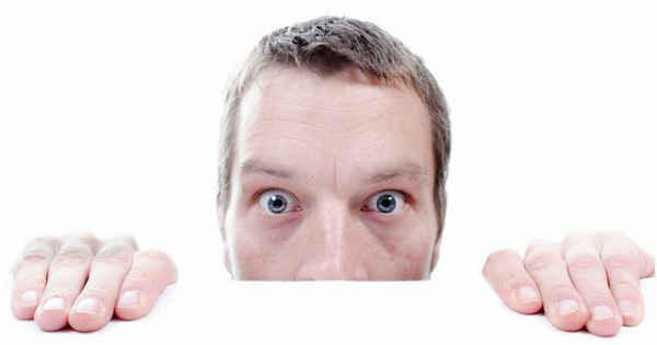 man hiding behind table