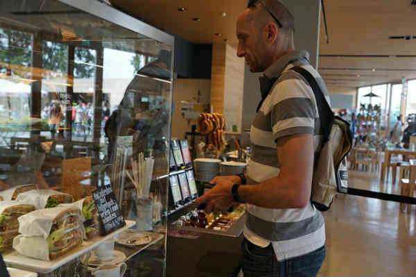 a man ordering food from a bakery