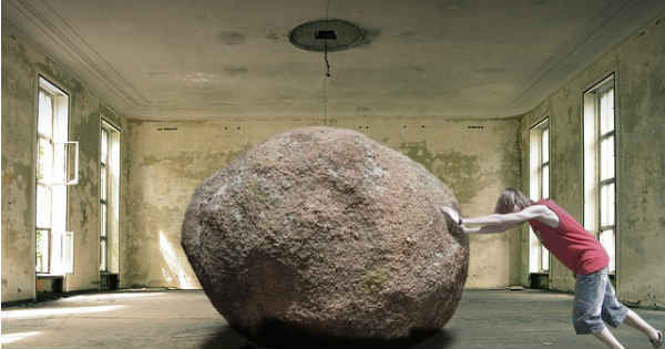man pushing a rock outside of a room