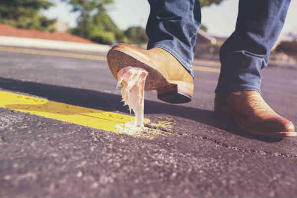 man stepped on a gum in the middle of the road