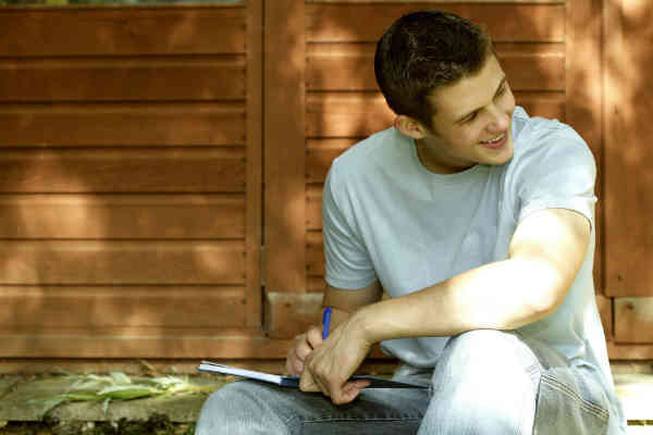 man writing in his journal