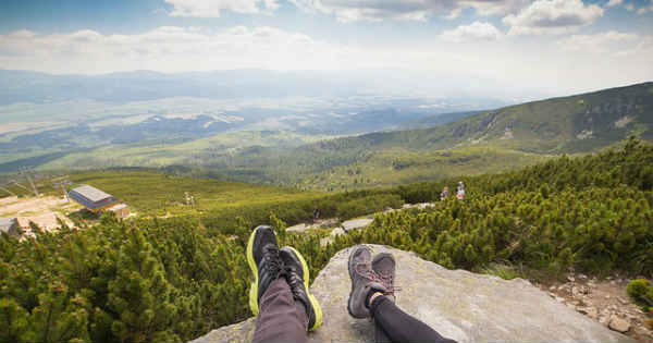 two people resting on mountain enjoying the view