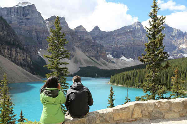 two people overlooking mountain top and lake