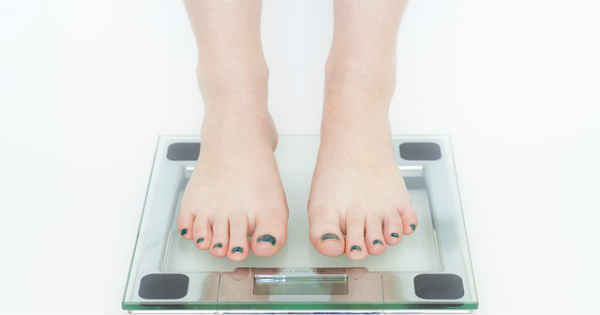 person measuring themselves on a bathroom scale