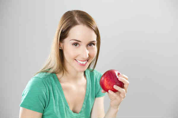 woman eating apple smiling