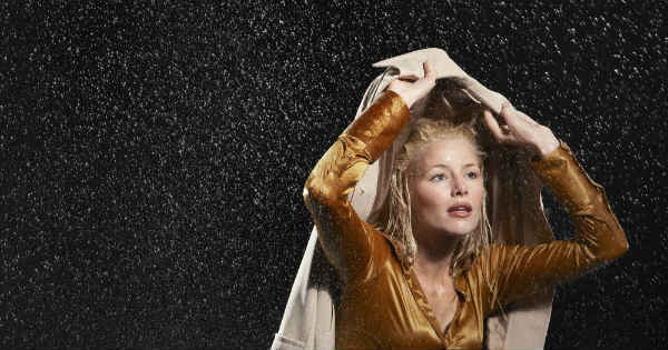 woman in rain with a coat over her head