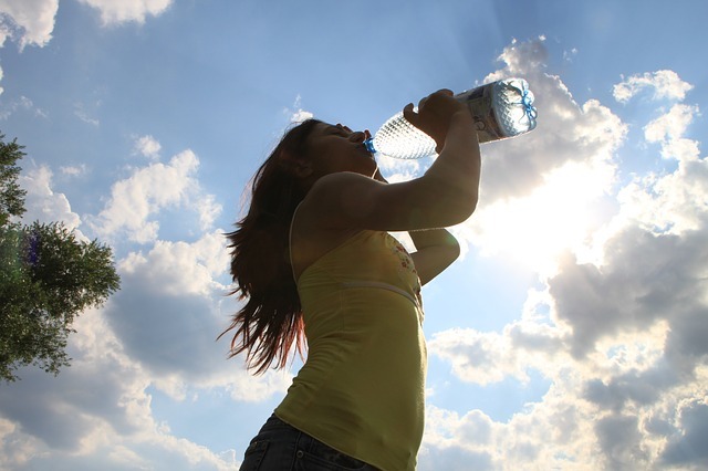 woman drinkign water from a plastic bottle