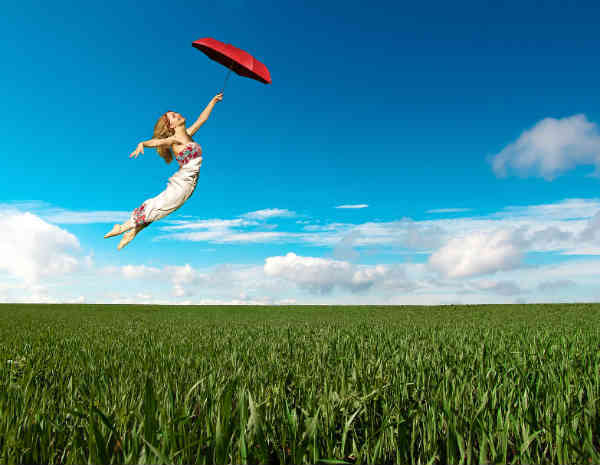 woman flying over the field with her umbrella