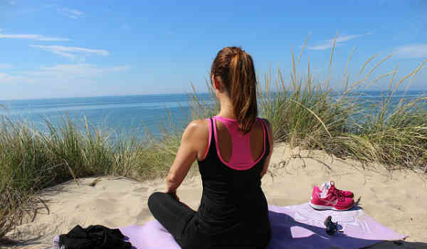 woman meditating on a beach