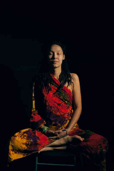 woman meditating in a dark room