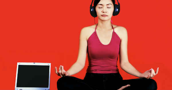 woman meditating with headphones and laptop