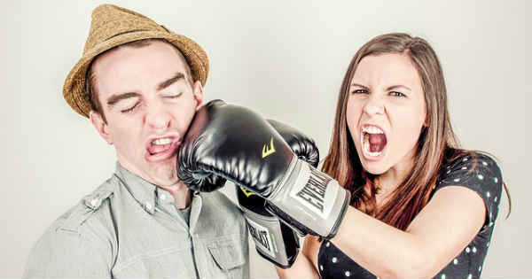 angry woman punching a man with a box glove