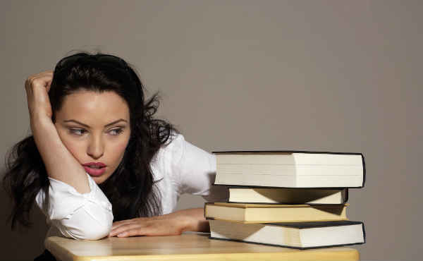 woman annoyed with a stash of books