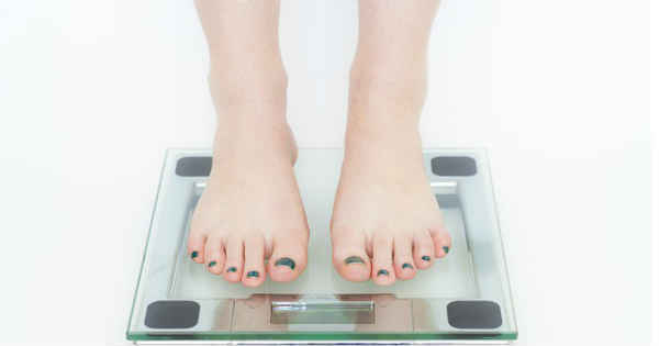 woman measuring herself on a scale